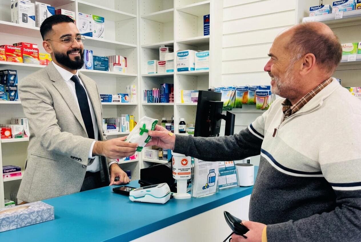 Asim Iqbal serving a patient at the Norton Fitzwarren Pharmacy counter in Taunton